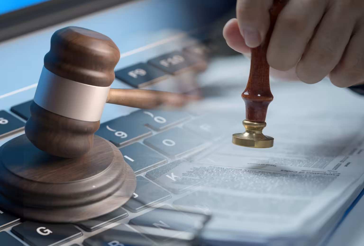 Gavel and notary stamp on top of legal documents and laptop keyboard